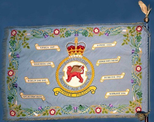 Please click this image for HM The Queen's presentation speech: the Standard, a fringed and tasselled silken banner, mounted on a pike surmounted by a Golden Eagle, was created by His late Majesty King George VI to mark the twenty fifth anniversary of the Royal Air Force in 1943. Squadrons qualify for the award of a Standard after twenty five years of service or for especially meritorious operations. Eight selected battle honours in scroll surround the Squadron badge. The decorative border is embroidered with the national emblems of the British Isles.  [image: Barry Goodwin]